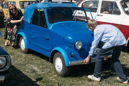 Kiev, Ukraine - May 01 2018: Woman and boy pushes old car outdoor