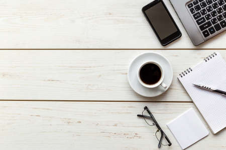 Office supplies and gadgets on a wooden table background. View from above.