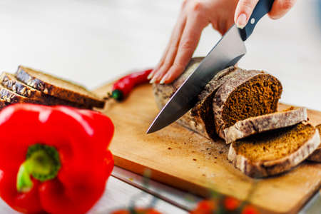 Woman Slicing Bread on a Cutting Board