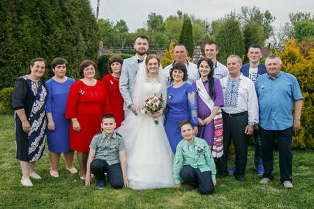 Cuman, Volyn / Ukraine - April 29 2018: Groom and bride with guests posing at parkのeditorial素材