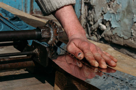 The hand of worker and sheet metal in rural workshopの写真素材