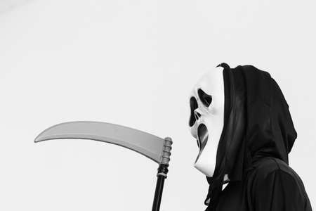 Scary monster with scythe in halloween conceptの写真素材