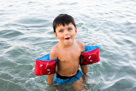 La Manga, Murcia / Spain - July 28 2018: The child in the sea to bathe with protective inflatable sleevesのeditorial素材