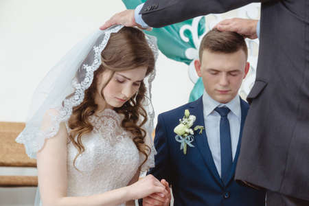Maryanivka, Volyn / Ukraine - May 21 2017: Hands of pastor on heads of bride and groom in churchのeditorial素材