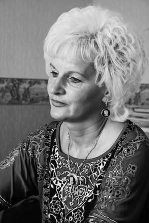 Kovel, Volyn / Ukraine - August 13 2010: Elegant middle aged woman with blond hair posing at homeのeditorial素材