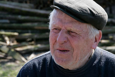 Lutsk, Volyn / Ukraine - April 03 2009: Senior man wearing cap posing on rural streetのeditorial素材