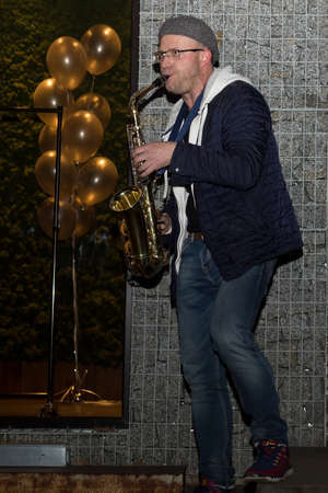 Lutsk, Volyn / Ukraine - November 17 2017: Man with saxophone outside at nightのeditorial素材