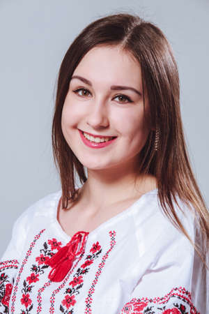 Lutsk, Volyn / Ukraine - March 21 2015: Ukrainian girl in a traditional embroidered shirt posing in studio against blank wallのeditorial素材