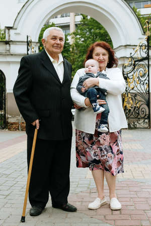 Lutsk, Volyn / Ukraine - May 18 2019: Senior couple with baby grandson posing on the streetのeditorial素材