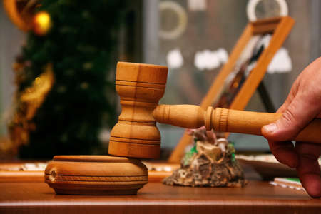 The auctioneer with a hammer during Christmas Charity Fair on blurred background