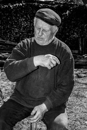 Lutsk, Volyn / Ukraine - April 03 2009: Senior man wearing cap posing on rural streetのeditorial素材