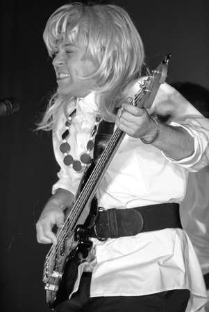 Lutsk, Volyn / Ukraine - November 24 2009: Ukrainian comedy male actor wearing wigs parody female music band during the performance in the theaterのeditorial素材