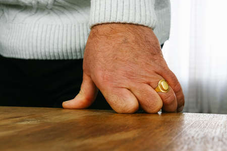 Hand of man with ring put on the desk. Shallow depth of field.の写真素材