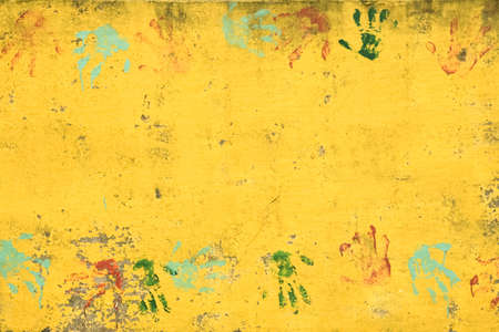 Set of colorful hand prints on bright yellow wallの写真素材