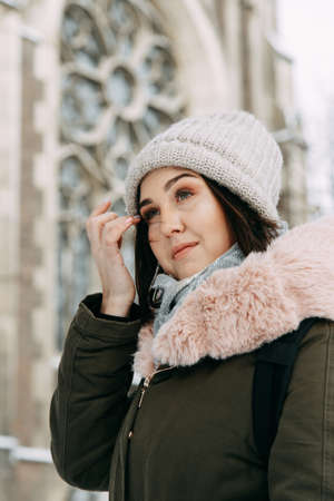 Lviv, Ukraine - December 30 2019: Young woman wearing warm coat and knitted autumn posing outside in a city street in cold seasonのeditorial素材
