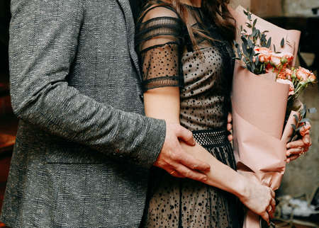 Partial view of man hugging wife with bouquet of flowersの写真素材