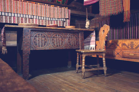 Interior of a old traditional Ukrainian house furnished with old wooden chair and tableの写真素材