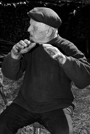 Lutsk, Volyn / Ukraine - April 03 2009: Senior man wearing cap posing on rural streetのeditorial素材