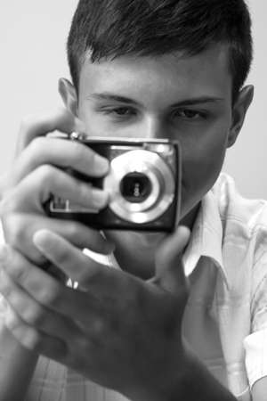 Lutsk, Volyn / Ukraine - July 12 2011: Teenage boy taking photo with compact camera in officeのeditorial素材