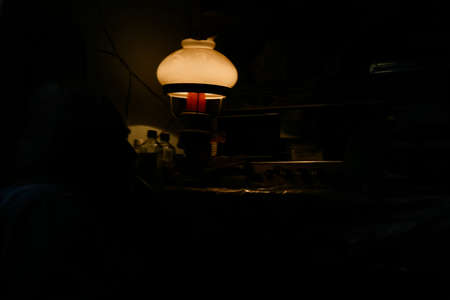Mulchyci, Rivne / Volyn - September 04 2012: Old man listening to Radio at home in evening