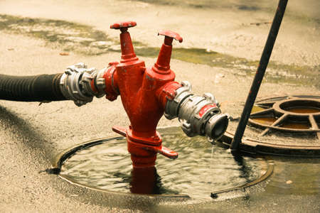 Fire hydrant with a fire hose attachedの写真素材