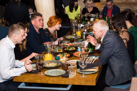 Lutsk, Volyn / Ukraine - November 17 2017: Men and women together while sitting at table in restaurantのeditorial素材
