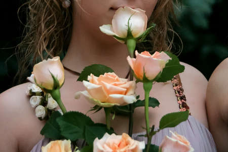 Close up part of young woman face and bouquet of rosesの写真素材