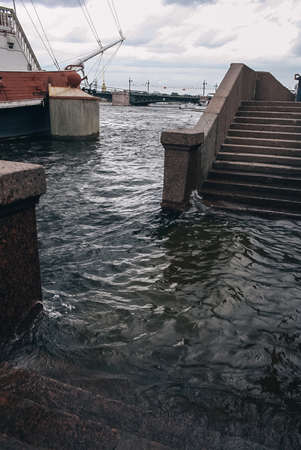 Flooded stairs and city granite embankment goes down to river water in Saint Petersburg, Russiaのeditorial素材