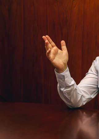 Raising hand of man in shirt at officeの写真素材