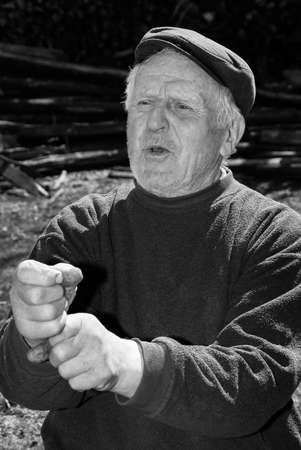 Lutsk, Volyn / Ukraine - April 03 2009: Senior man wearing cap posing on rural streetのeditorial素材