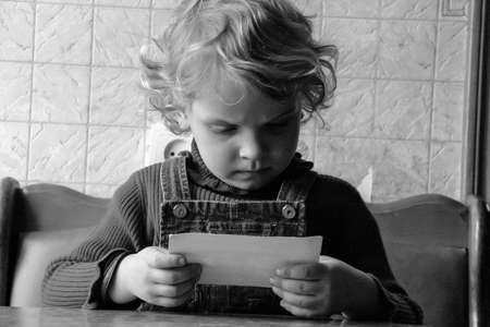 Volodymyrec, Rivne / Ukraine - April 10 2009: Little girl posing with old photography at home