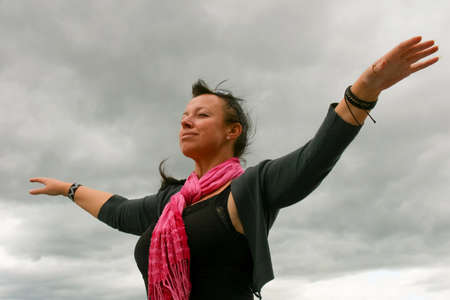 Woman standing in free freedom pose raised hands up towards the sky with a joyful emotion on her...