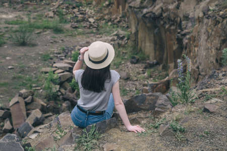 Slim young woman in hat on the the background of rocky careerの写真素材