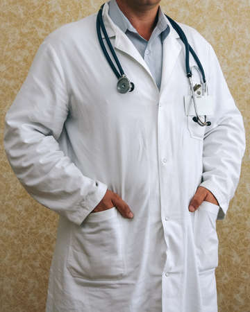 Close up of male doctor with stethoscope over wall backgroundの写真素材
