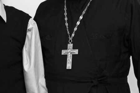 Cropped view of casual man and orthodox priest with a cross
