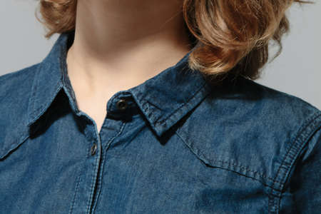 Woman wearing denim shirt. Close up studio shot.