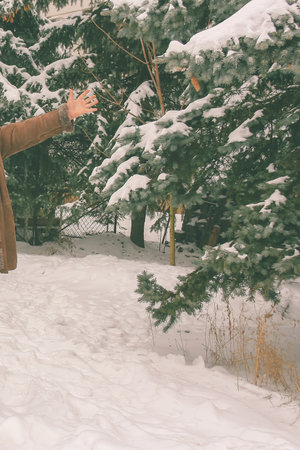 Man enjoy life next to the snowy trees in winter. Cropped view.