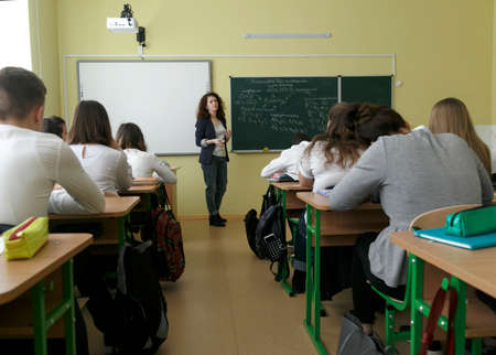 Lutsk, Ukraine - February 21 2019: Female Tutor next to chalkboard Teaching Maths Class at High Schoolのeditorial素材
