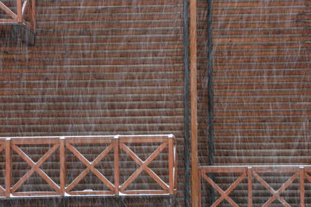 Fragment of the facade of a wooden house during a heavy snowfall. Effect of motion.の写真素材
