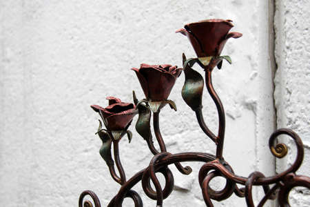 Forged metal roses. Decorative elements of wrought iron gates. Shallow depth of field.の写真素材