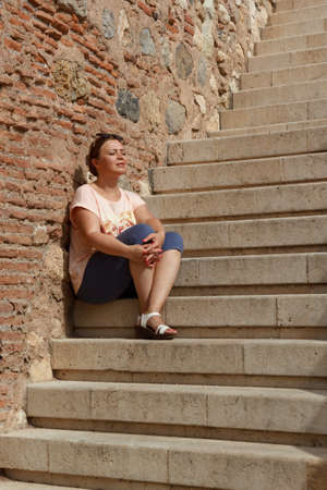 Woman sitting on the staircase of the Alcazaba in Almeria, Spainの写真素材