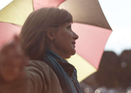 Woman with an umbrella in the rays of a sun. Shallow depth of field.の写真素材