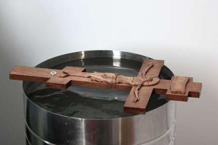 Orthodox wooden cross prepared for the consecration of water lies on a bowl