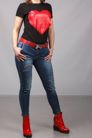 Young female model wearing ripped jeans and t-shirt with print of heart. Cropped view.の写真素材