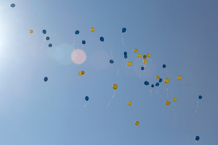 Yellow and blue balloons are flying high in the sky. Colors of the Ukrainian flag. Celebration of...