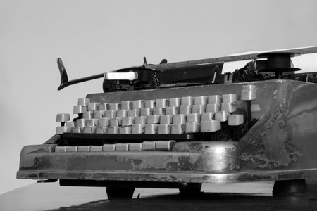 Old typewriter with blank paper sheet on wooden tableの写真素材