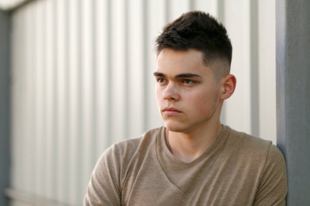 Casual young man standing outdoors. Shallow depth of field.の写真素材