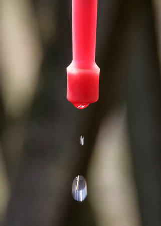 Drop of water dangling on part of plastic washstand in the village. Close-upの写真素材
