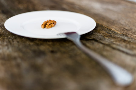 Walnut in a plate and fork on a wooden background. Shallow depth of field.の写真素材