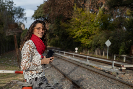 Young Latin American businesswoman waits by the train tracksの写真素材